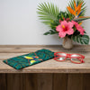 Canvas glasses slip case featuring two stylised gouldian finches on a branch against a leafy teal and green background