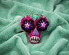 Hot pink sugar skull brooch with black and purple flower eyes