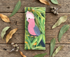 Canvas glasses slip case featuring a galah perched among gum leaves on a rustic timber surface surrounded by gum leaves and gum nuts