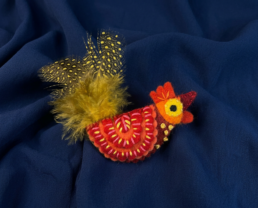 orange and red felt rooster brooch with yellow and black spotty tail feathers