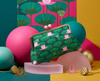 Clutch purse with pale pink ball closure and a pattern of pink sacred lotus, seed pods and lily pads in blue-green tones