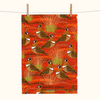 linen tea towel patterned with stylised spinifex pigeons and spinifex on a background of orange mounds
