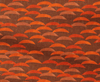 Patterned fabric with orange and brown shapes on a brown background