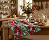 Linen tea towel with pattern of rosella blossoms and leaves on a pale blue background in a rustic kitchen
