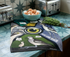 linen tea towel printed with a comic book style graphic about bush stone curlews on a kitchen bench with a bowl of eggs and a bunch of rosemary