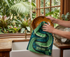 an image in a kitchen of someone drying dishes with a linen tea towel featuring a stylised pattern of saltwater crocodiles