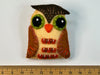 Brown and pale yellow eye felt brooch with green eyes