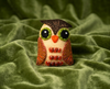 Brown and pale yellow eye felt brooch with green eyes